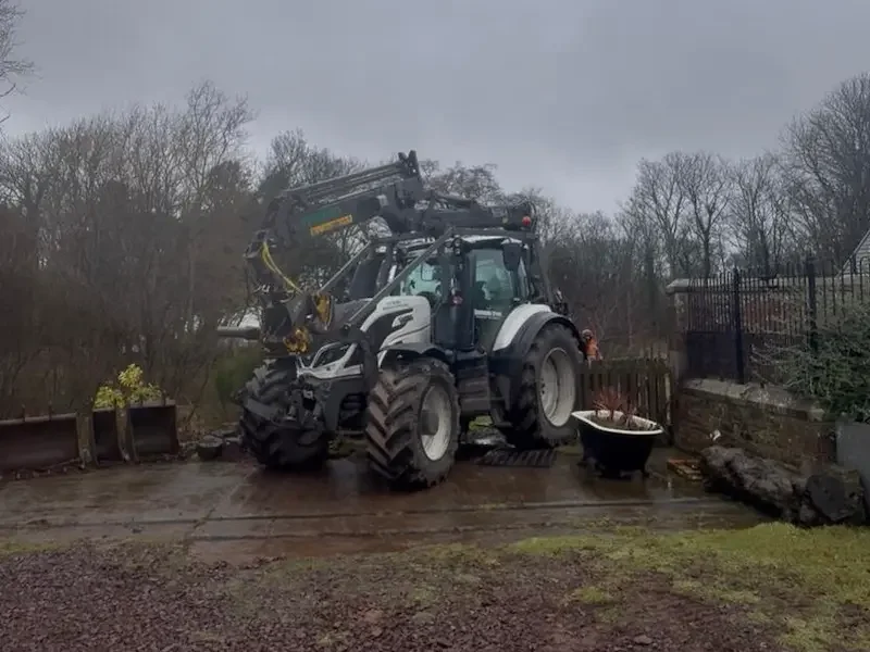 Tractor with crane comes in useful for lifting heavy timber out of gardens and over walls and fences